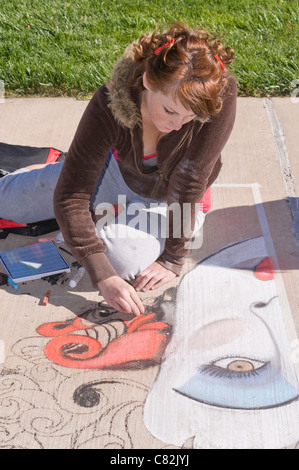 Ein Teen Bürgersteig Kreide Künstler schafft eine fantasievolle Bild an der Kreide-Kunst-Festival, Roswell Museum and Art Center, Roswell, NM. Stockfoto