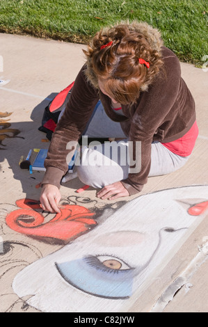 Ein Teen Bürgersteig Kreide Künstler schafft eine fantasievolle Bild an der Kreide-Kunst-Festival, Roswell Museum and Art Center, Roswell, NM. Stockfoto