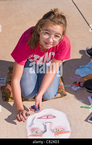 Ein Teen Bürgersteig Kreide Künstler schafft eine fantasievolle Bild an der Kreide-Kunst-Festival, Roswell Museum and Art Center, Roswell, NM. Stockfoto