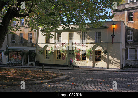 Die gepflasterten Abtei grün mit einer zentralen Platane und umliegenden Geschäfte in Bath, N.E. Somerset, England, UK Stockfoto