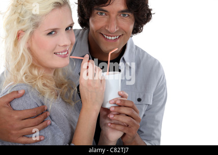 schönes paar aus demselben Becher mit Strohhalm trinken Stockfoto