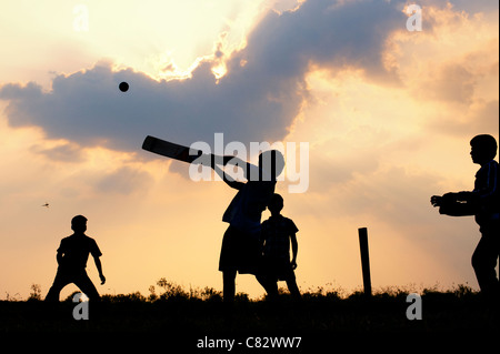 Silhouette von indischen jungen Fussball vor einem bewölkten Sonnenuntergang Hintergrund. Indien Stockfoto