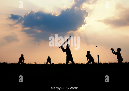 Silhouette von indischen jungen Fussball vor einem bewölkten Sonnenuntergang Hintergrund. Indien Stockfoto