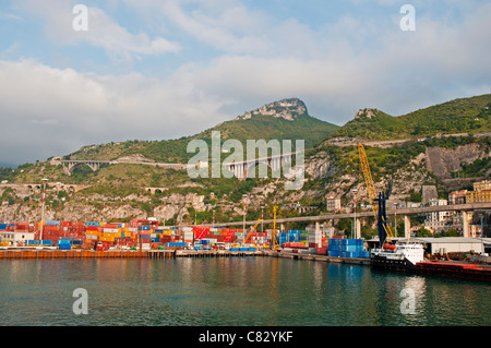 Ein Handelsschiff, geladen mit Ladung im Hafen von Rom, flankiert von den grünen Bergen im Hintergrund, Civitavecchia, Italien Stockfoto