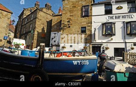 Kleines Fischerboot vor dem Bay Hotel in Robin Hoods Bay, Yorkshire, England. Stockfoto