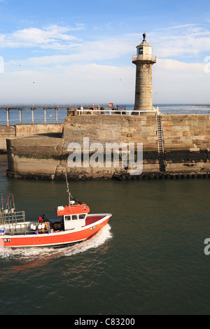 Angelboot/Fischerboot vorbei zum Leuchtturm an der Einfahrt zum Hafen von Whitby. Stockfoto