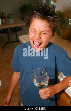 Japanisch/kaukasischen 9-10 Jahre alter Junge nimmt Pille mit Glas Wasser. Herr © Myrleen Pearson Stockfoto