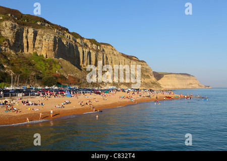 Leute, Sonnenbaden im Oktober am Strand unter Rock-a-Nore Klippen an Hastings, East Sussex, England, UK, GB Stockfoto