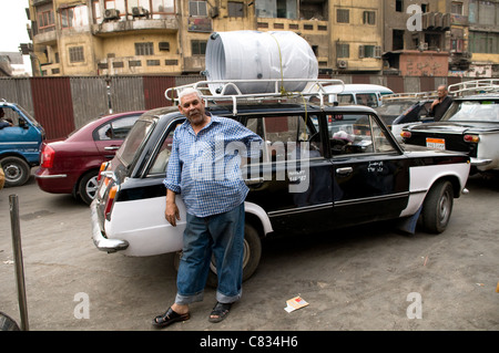 Ein ägyptischer Taxifahrer durch seine alten Taxi in Kairo stehen. Stockfoto