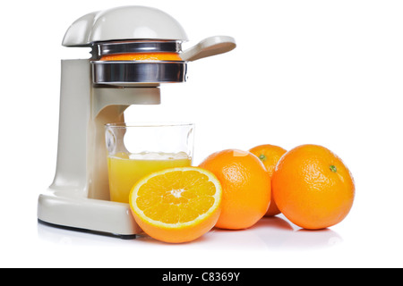Foto von einem Entsafter und ein Glas frisch gepressten Orangensaft, isoliert auf einem weißen Hintergrund. Stockfoto