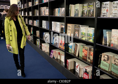 Eine Frau in einem Waterstone Buchhandlung / Zelt, betrachten und bereiten sich auf die Bücher auf dem Cheltenham Literaturfestival zu kaufen. Stockfoto