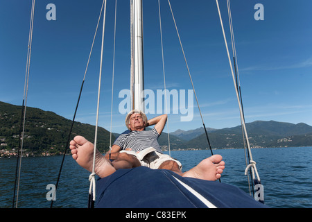 Älterer Mann entspannend auf Segelboot Stockfoto