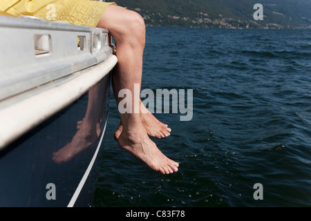 Frau baumelnden Füße vom Segelboot Stockfoto