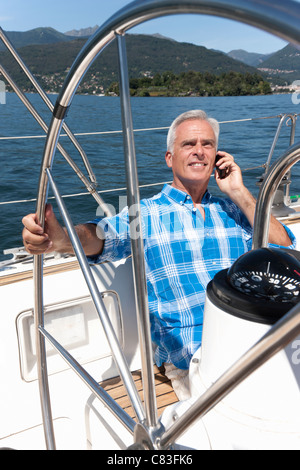 Älterer Mann am Telefon auf Segelboot Stockfoto