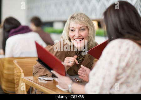 Geschäftsfrauen lesen Menüs am Mittag Stockfoto