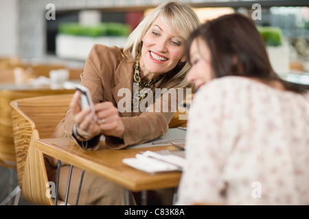 Geschäftsfrauen Blick auf Handy Stockfoto
