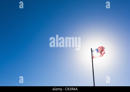 Amerikanische Flagge gegen Sonne und blauer Himmel Stockfoto