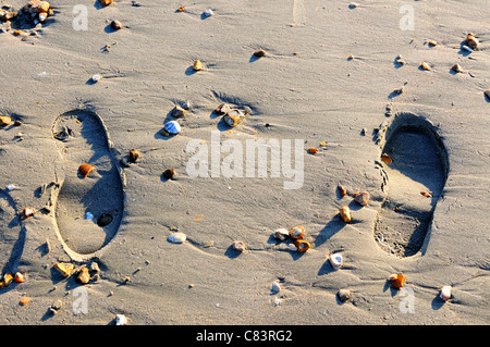 Impressionen der Schuhe im nassen Sand auf West Wittering der Strand bei Ebbe West Sussex, UK Stockfoto