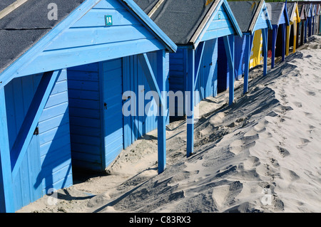 Einige der 156 verwitterten Strandhütten von West Wittering zeigen die eindringenden "Moving" Dünen, die drohen, sie zu begraben - West Sussex, England Stockfoto