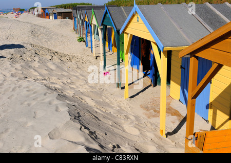 Einige der 156 verwitterten Strandhütten von West Wittering zeigen die eindringenden "Moving" Dünen, die drohen, sie zu begraben - West Sussex, England Stockfoto