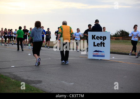 Halten Sie linke Zeichen, Läufer und Walker in der Goodlife Fitness Marathon in Victoria BC Kanada zu lenken Stockfoto