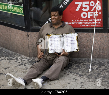 Blinder Mann sitzt auf der 34th Street um Almosen bitten. NEW YORK CITY. Stockfoto