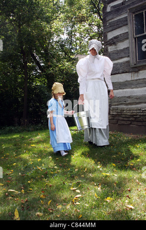 Eine Frau und ein Kind tragen eine blasse auf einem Bauernhof Stockfoto