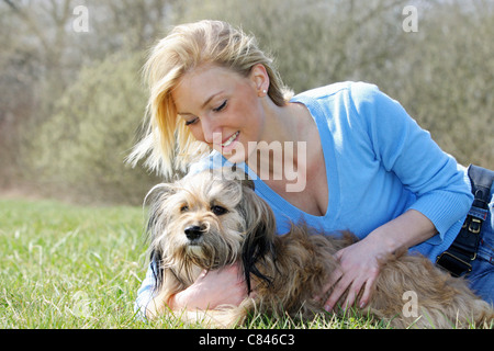 junge Frau mit Havenese Hund auf Wiese Stockfoto