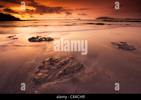 Wellen über die Felsen am Strand Stockfoto