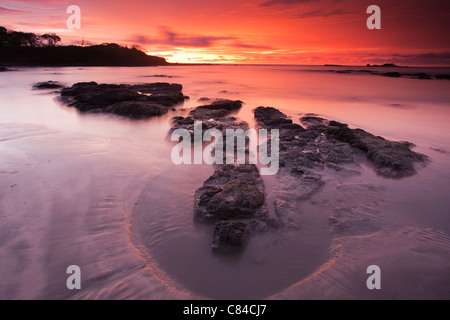 Wellen über die Felsen am Strand Stockfoto