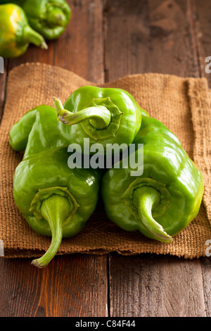 Grüner Paprika auf Jute und Holz Stockfoto