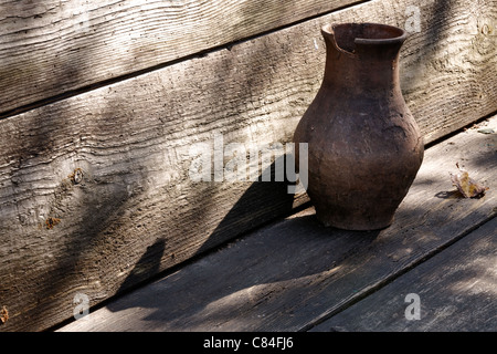 Gebrochene Tontopf auf ein rustikales Holzregal Stockfoto