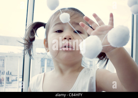 Kleine Mädchen spielen mit hängende Dekoration Stockfoto