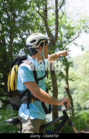 Mann Motorrad Reiten im Wald, Richtung zeigen Stockfoto