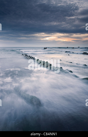 Wellen über die Felsen am Strand Stockfoto