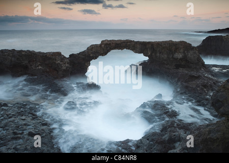 Wellen über die Felsen am Strand Stockfoto