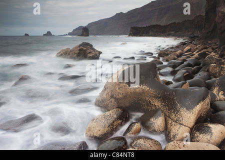 Wellen über die Felsen am Strand Stockfoto