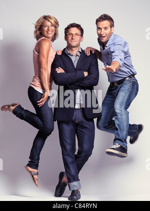 Lizenz erhältlich unter MaximImages.com - künstlerisches Porträt von Lächeln lässig, aber mit Stil gekleidet zwei Männer und eine Frau in Jeans Stockfoto