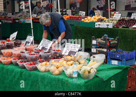 Mann verkauf Schalen von Obst auf einem Marktstand. England, Großbritannien, Großbritannien Stockfoto