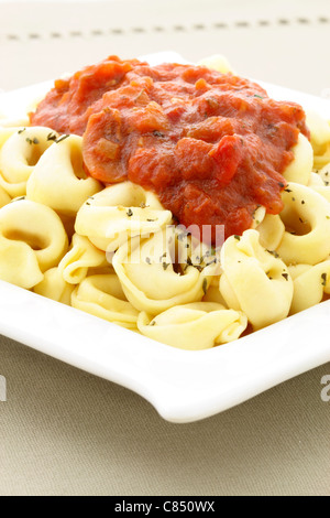 lecker gefüllte Tortellini mit marinara Sauce und Basilikum obenauf Stockfoto