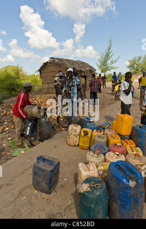 Menschen trinken Wasserholen in Behältern aus einem öffentlichen Hahn, Quelimane, Mosambik Stockfoto