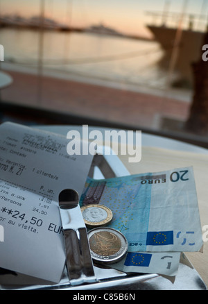 Restaurant Rechnung Spanien Euro-Banknoten und -Münzen Zahlung in Euro am luxuriösen Restaurant am Wasser Tisch Sonnenuntergang Puerto Portals Palma de Mallorca Spanien Stockfoto