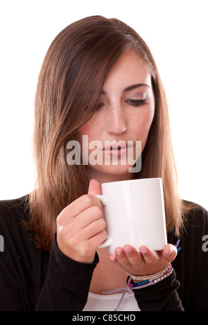junge Frau bläst um ihre Tasse Tee abkühlen Stockfoto