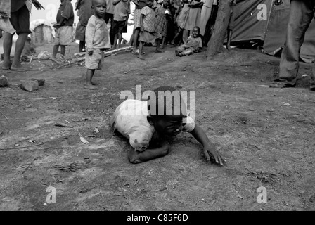 Der Junge kriecht auf dem Boden und weint in einem Lager für Binnenvertriebene in der Provinz Nord-Kivu in der Demokratischen Republik Kongo, Afrika Stockfoto