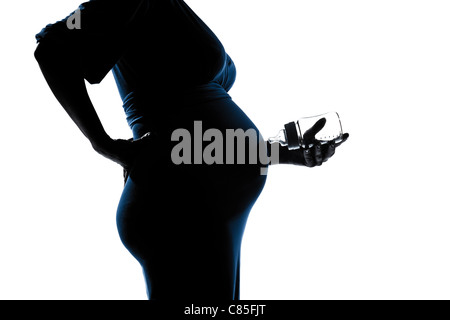 schöne kaukasischen schwangere Frau mit Babyflasche Silhouette auf weißem Hintergrund Studio isoliert Stockfoto