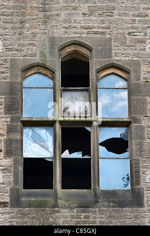 Die Fenster wurden von Vandalen in einem leeren und verlassenen viktorianischen Gebäude, Großbritannien, zerbrochen Stockfoto