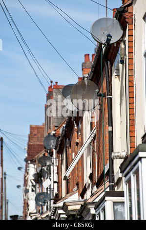 Satellitenschüsseln Krempel die Front der Häuser auf einem britischen street.upright-Format. Stockfoto