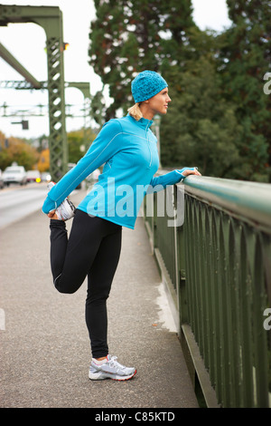 Stretching der Frau auf der Brücke beim Jogging, Seattle, Washington, USA Stockfoto
