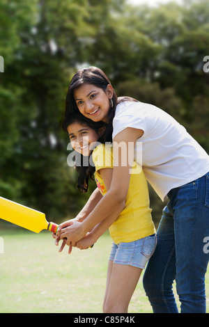 Mutter und Tochter spielen cricket Stockfoto