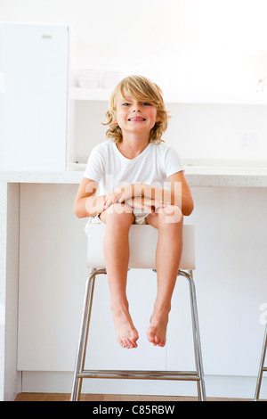 Kleiner Junge sitzt auf Küchenhocker Stockfoto